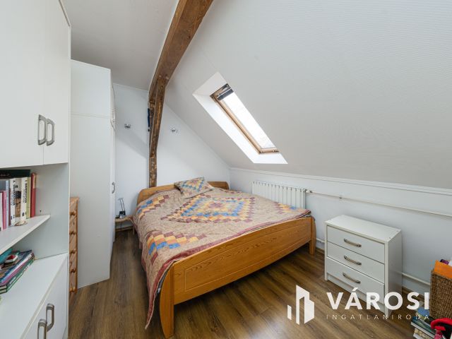 Látszó fagerendás tetőtéri lakás csendes utcában